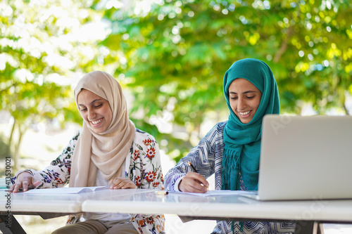 Canvas Print Education concept: Young Muslim students are writing and smiling