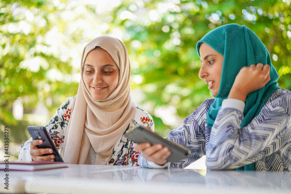 Selective focus on Muslim girls using smartphone Selective focus on Muslim girls using smartphone