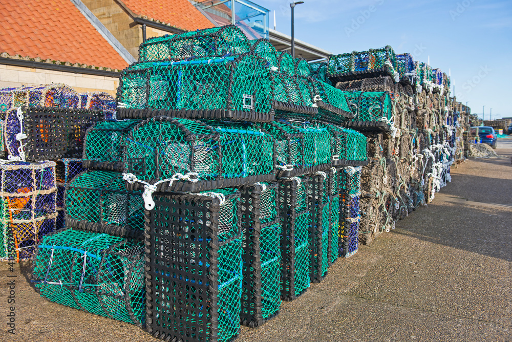 Lobster pots stacked up on a harbor quayside