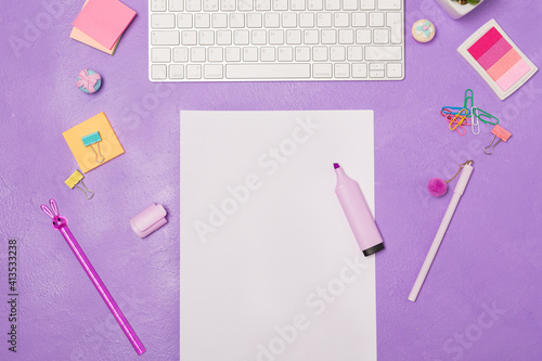 Bright vivid Flat lay workspace. Blank paper list and highlighter. Stationary and keyboard on bright violet purple background, top view. Girly work desktop. Copy space. School concept. 