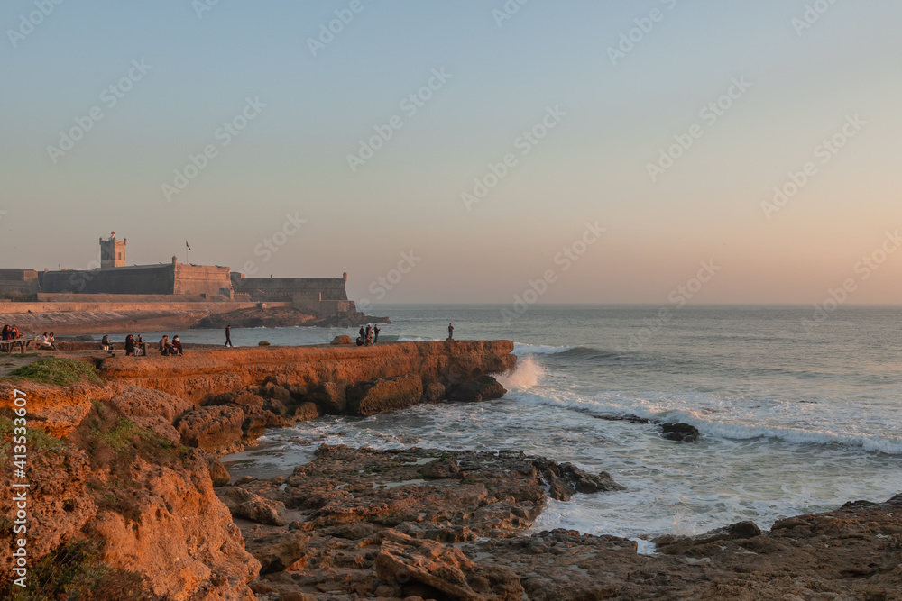 Sunset of a maritime Fortress in Portugal in the Atlantic Ocean and families walking Sunset of a maritime Fortress in Portugal in the Atlantic Ocean and families walking