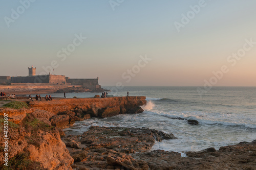 Sunset of a maritime Fortress in Portugal in the Atlantic Ocean and families walking