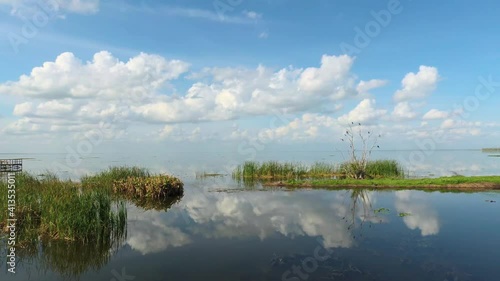Brilliant blue sky and clouds reflect on Lake Apopka at Winter Garden Florida