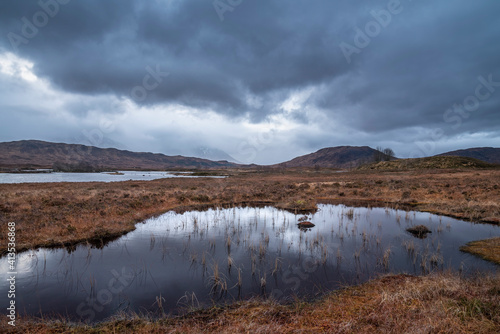 Epic dramatic landscape image of Loch Ba on Rannoch Moor in Scottish Highlands on a Winter morning