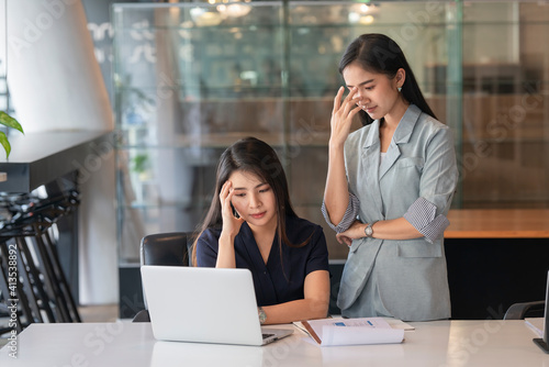 Portraits of two businesswomen consulting on their project while working in office room.