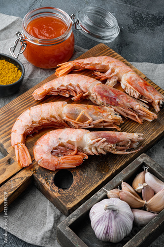 Raw shrimps with garlic, lime , mango sauce and curry for grill, on gray background