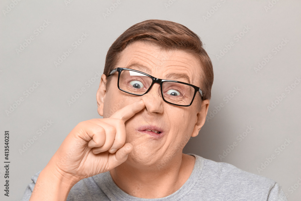 Portrait of funny man making goofy crazy face and picking his nose Portrait of funny man making goofy crazy face and picking his nose