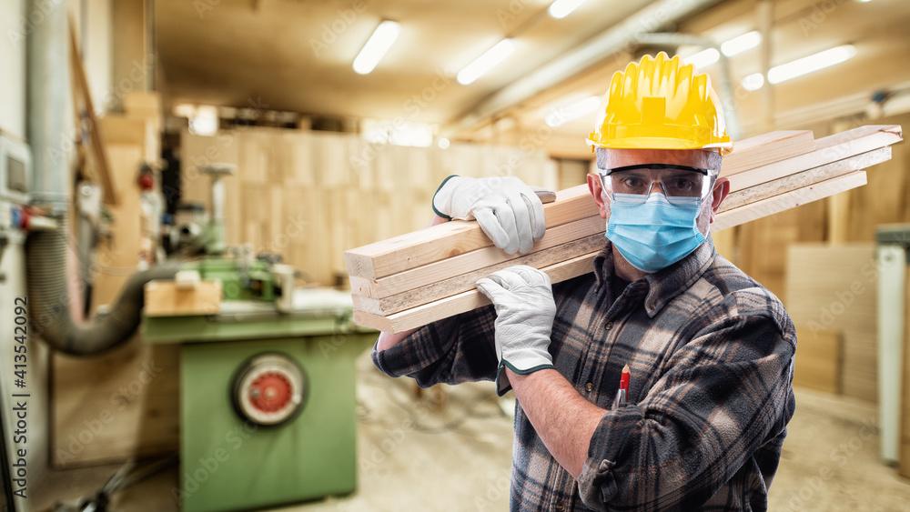 Carpenter worker at work in the carpentry wears helmet