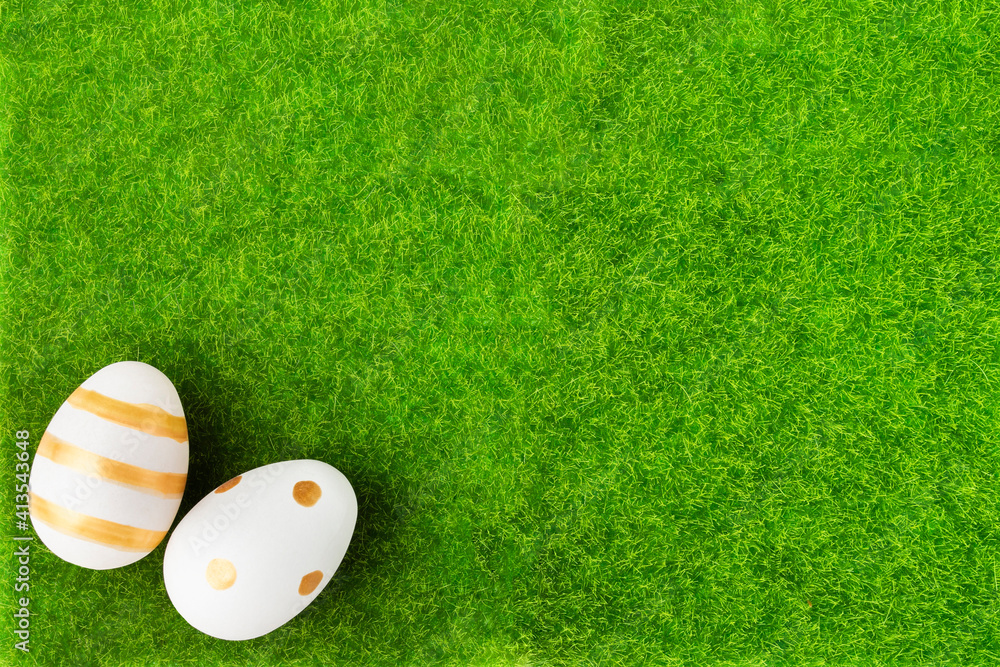 Naklejka premium Easter sunday brunch concept, gold eggs on green grass, holiday background with copy space