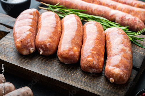 Traditional raw sausages, on black background
