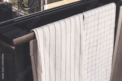 White kitchen towel hangs on the oven handle, product mockup