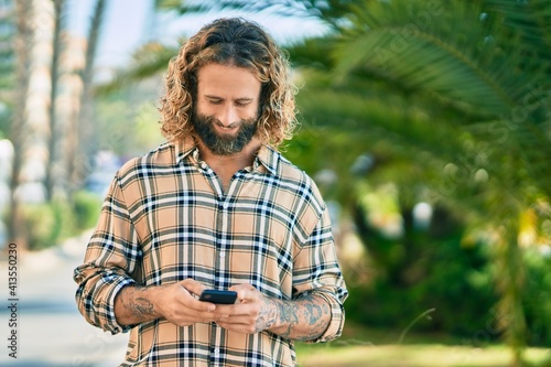 Young caucasian man smiling happy using smartphone at the park. © Krakenimages.com