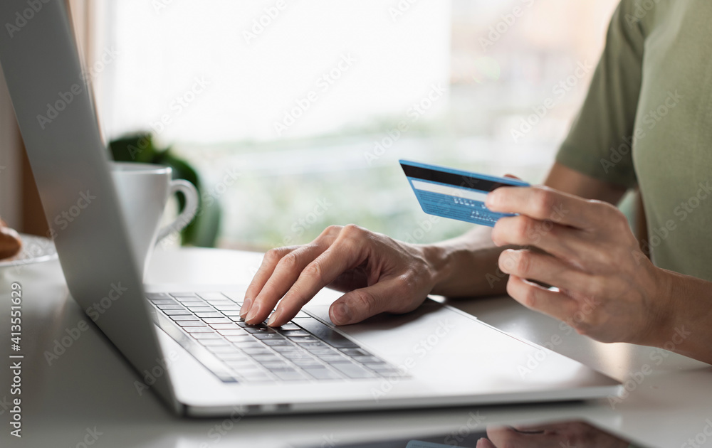 Woman using laptop computer with credit card making online payment. Business, online shopping, e-commerce, internet banking, spending money, working from home concept Woman using laptop computer with credit card making online payment. Business, online shopping, e-commerce, internet banking, spending money, working from home concept
