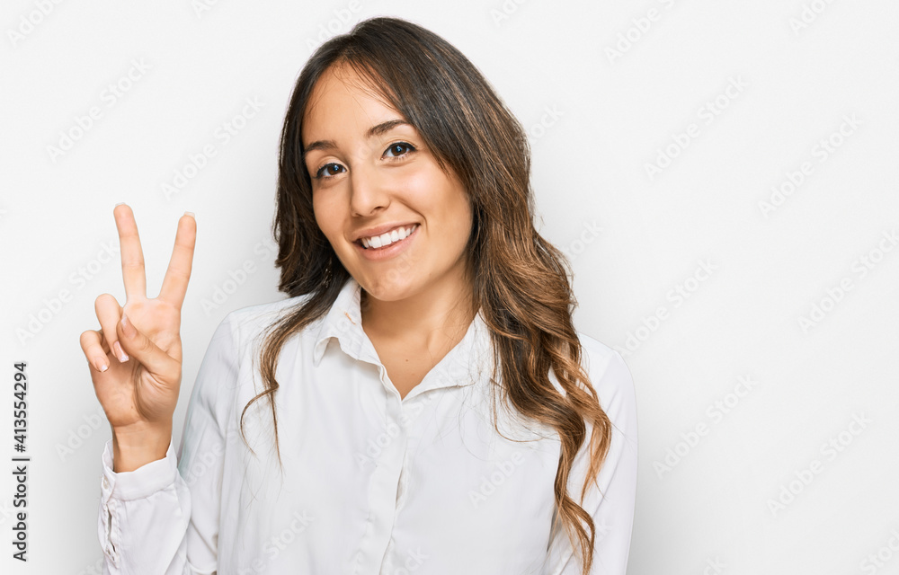 Young brunette woman wearing casual clothes showing and pointing up with fingers number two while smiling confident and happy. Young brunette woman wearing casual clothes showing and pointing up with fingers number two while smiling confident and happy.