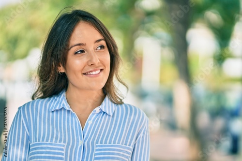 Young hispanic woman smiling happy standing at the park.