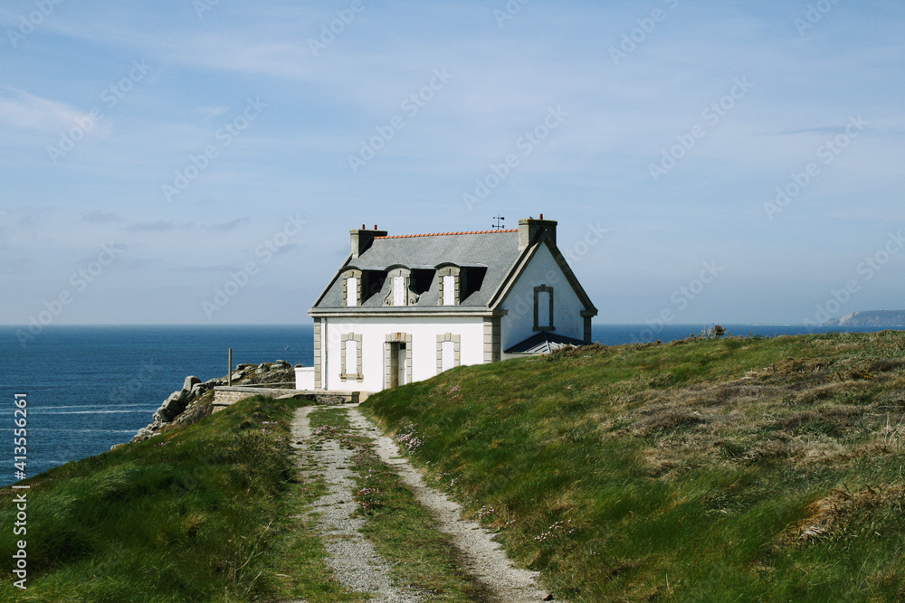 lighthouse house with green lawn and blue ocean. Brittany, France lighthouse house with green lawn and blue ocean. Brittany, France
