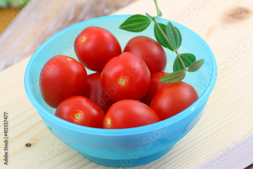 Obraz na płótnie Ripe and sweet cherry tomatoes in blue plastic bowl
w salonie