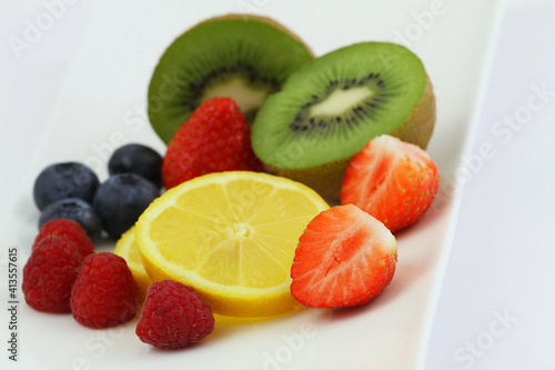 Obraz na płótnie Best source of Vitamin C: strawberries, bluberries, raspberries, kiwi fruit and lemon on white plate
w salonie