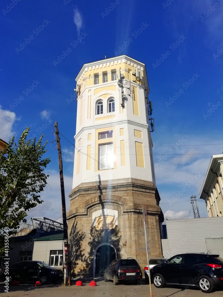 Fototapeta premium Yekaterinburg, Russia - 20.09.2020: Old water tower. Building with craquelures on yellow colour. 