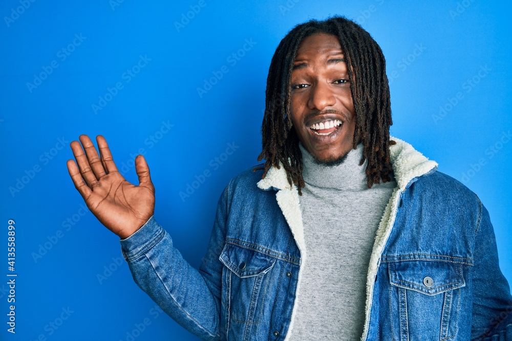 African american man with braids wearing casual denim jacket celebrating victory with happy smile and winner expression with raised hands African american man with braids wearing casual denim jacket celebrating victory with happy smile and winner expression with raised hands
