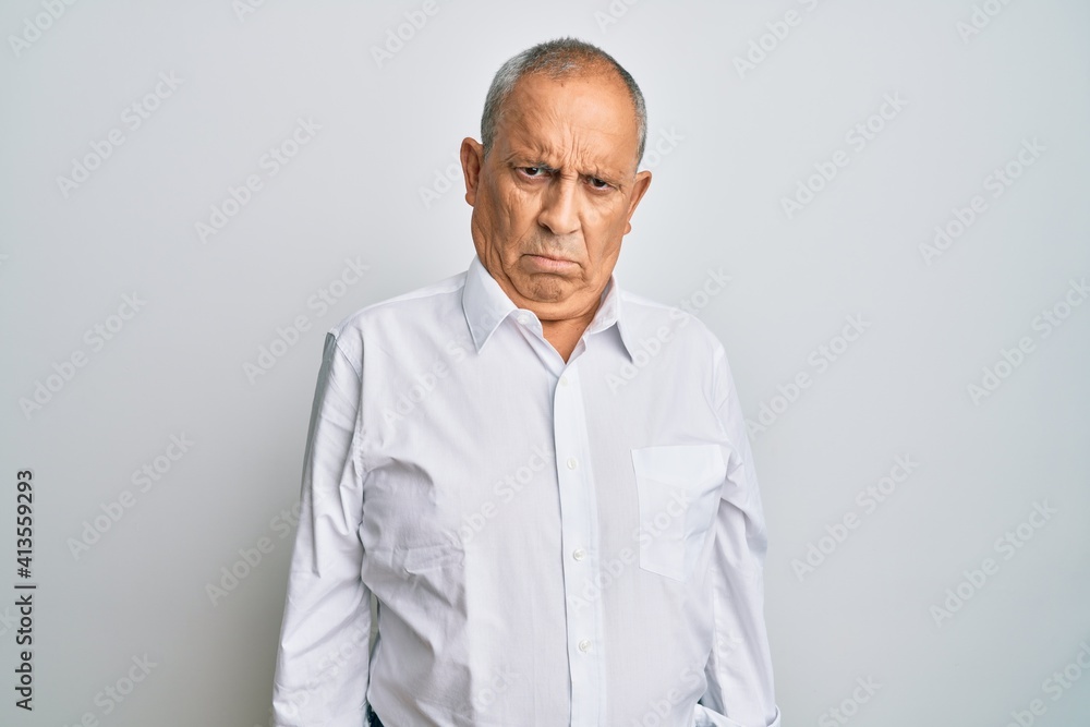 Handsome senior man wearing casual white shirt skeptic and nervous, frowning upset because of problem. negative person. Handsome senior man wearing casual white shirt skeptic and nervous, frowning upset because of problem. negative person.