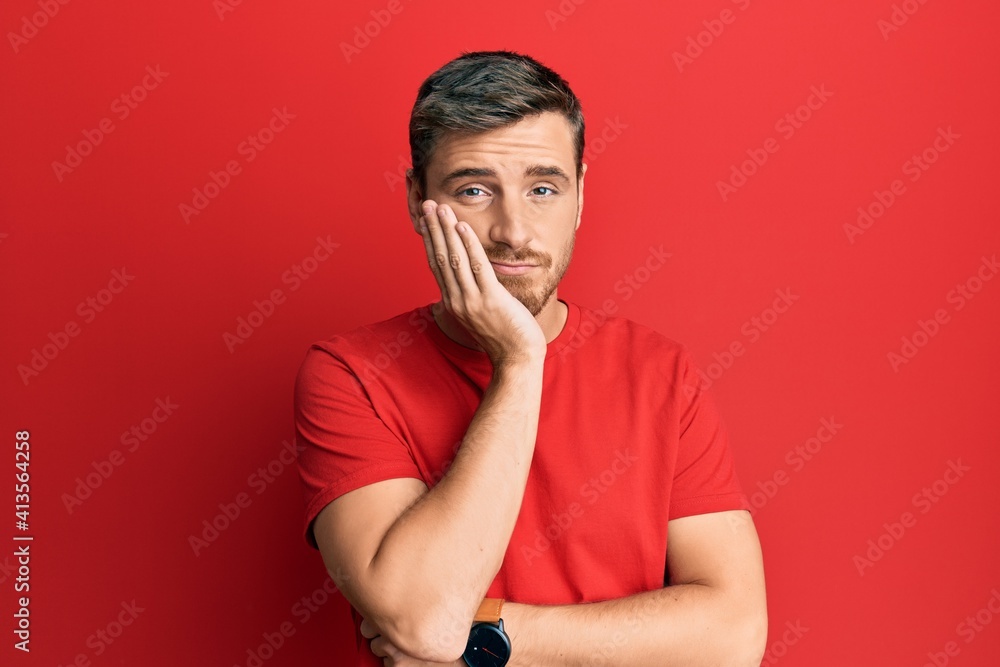 Handsome caucasian man wearing casual red tshirt thinking looking tired and bored with depression problems with crossed arms. Handsome caucasian man wearing casual red tshirt thinking looking tired and bored with depression problems with crossed arms.