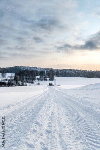 Winter landscape, road after snowfall, clouds in the sky, north nature