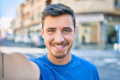 Young caucasian man smiling happy making selfie by the camera at the city.