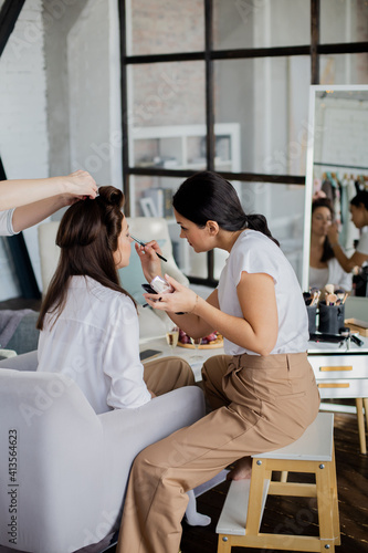 Woman makeup artist and hairdresser getting ready female to event wedding or important meeting