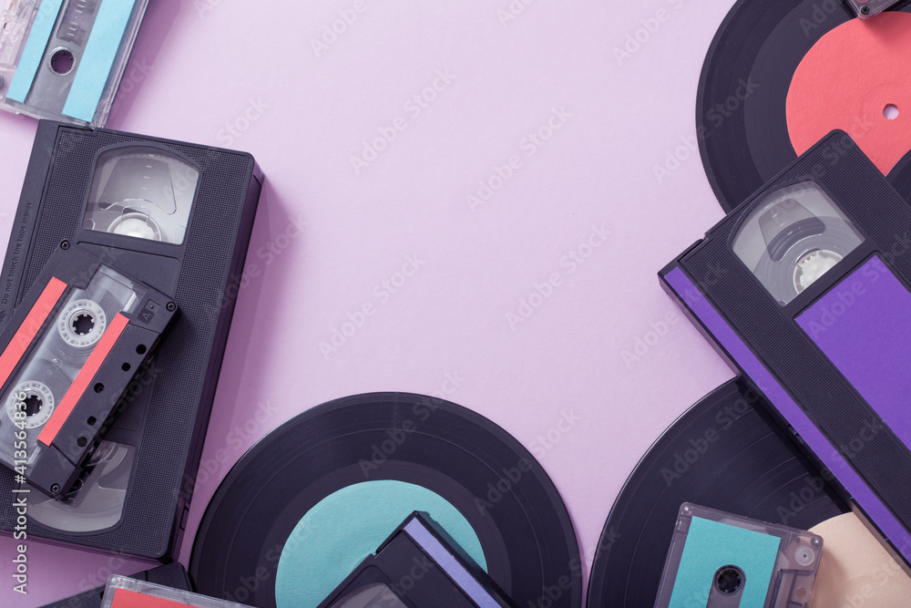 Collection of music tapes, records and video cassettes on paper background. Retro concept Collection of music tapes, records and video cassettes on paper background. Retro concept
