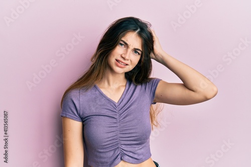 Young caucasian woman wearing casual clothes confuse and wonder about question. uncertain with doubt, thinking with hand on head. pensive concept.