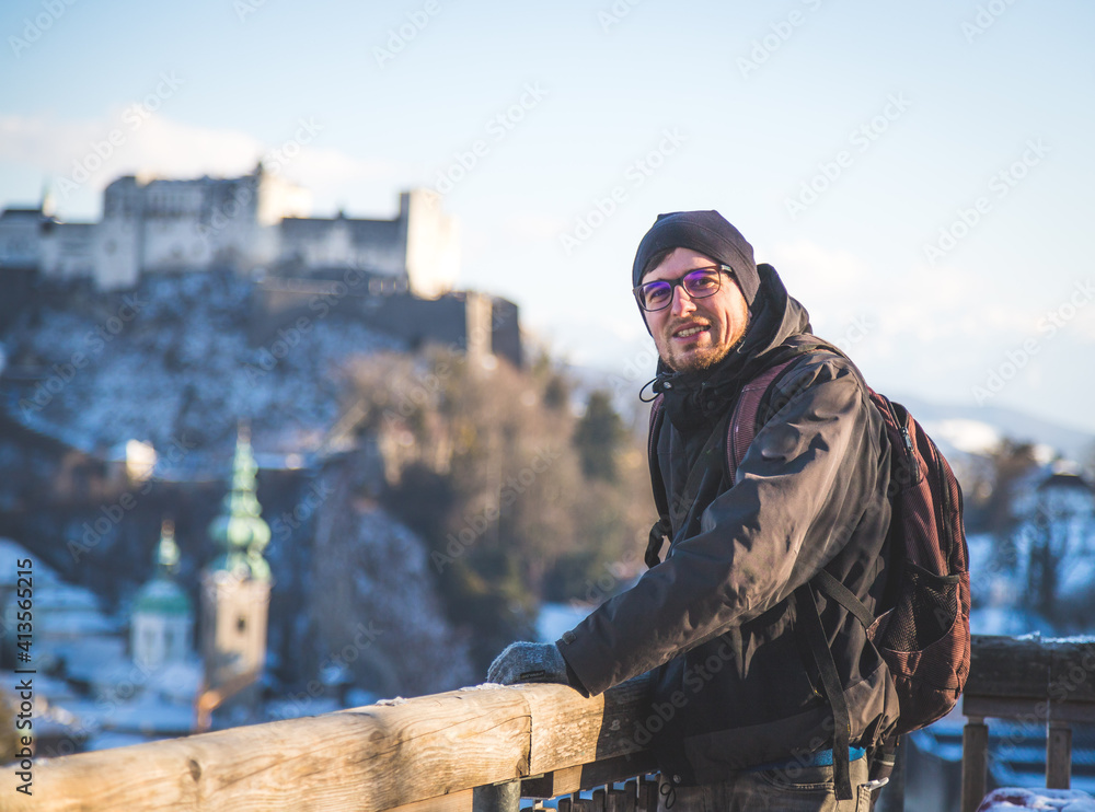 Obraz premium Enjoying the view over Salzburg: Young tourist man on the viewing platform