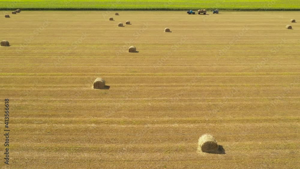 Flying over harvested field with collected hay bales. Landscape field meadow with hay bales after harvest. Flying over harvested field with collected hay bales. Landscape field meadow with hay bales after harvest.