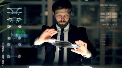 An engineer designs an electric drone using futuristic programs and holographic projection . Concept of: drone, Machine learning, future, project and augmented reality