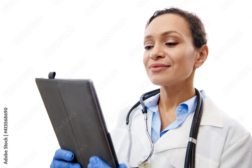 Cheerful doctor with stethoscope around her neck holding digital tablet on hands isolated on white background with copy space Cheerful doctor with stethoscope around her neck holding digital tablet on hands isolated on white background with copy space