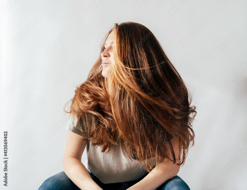 Portrait of adorable red-haired young woman with flying long hair. Happy funny emotional move Portrait of adorable red-haired young woman with flying long hair. Happy funny emotional move