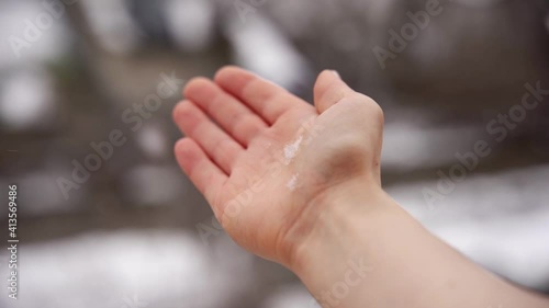 Catching white snowflakes in a winter storm with the right hand out of the window. Chasing snow while it is falling down during winter season.