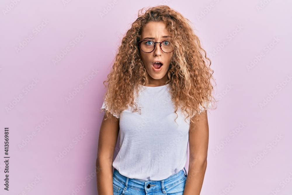 Beautiful caucasian teenager girl wearing white t-shirt over pink background afraid and shocked with surprise expression, fear and excited face. Beautiful caucasian teenager girl wearing white t-shirt over pink background afraid and shocked with surprise expression, fear and excited face.