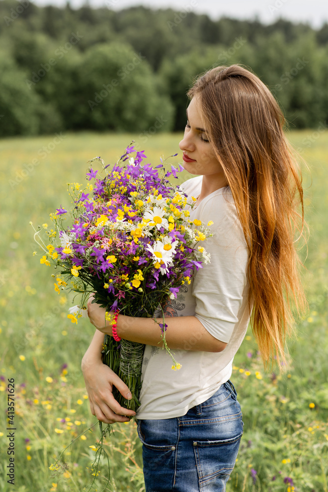 beautiful young girl in a field with a bouquet of flowers. beautiful young girl in a field with a bouquet of flowers.