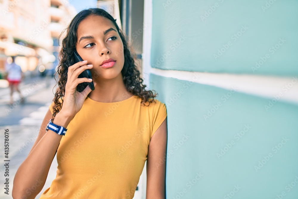 Fototapeta premium Young african american girl with unhappy expression talking on the smartphone at city.