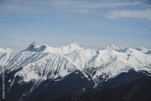 Alpine landscape, slopes of high mountains with glaciers against the blue sky. © Evgenii Starkov