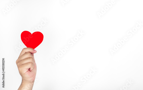 Man's hand holding red paper, heart-shaped, white background