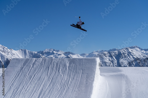 Skier performing an inverted trick in a snowpark in Austria on a sunny day