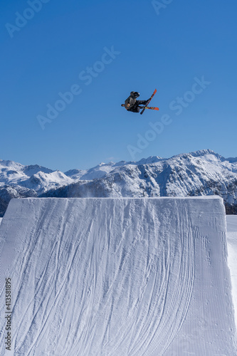 Skier performing an inverted trick in a snowpark in Austria on a sunny day
