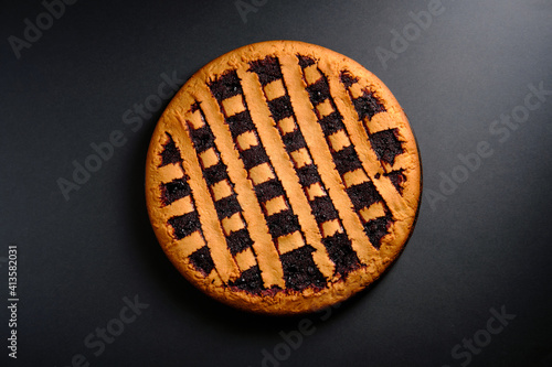 Berry pie in a baking dish on a dark background