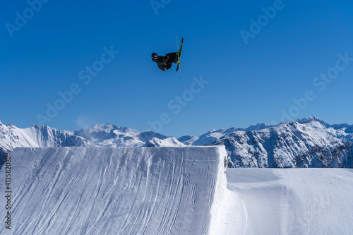 Skier performing an inverted trick in a snowpark in Austria on a sunny day