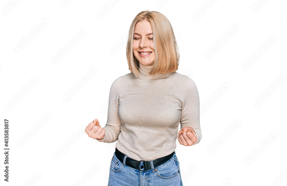 Fototapeta premium Young blonde woman wearing casual clothes very happy and excited doing winner gesture with arms raised, smiling and screaming for success. celebration concept.