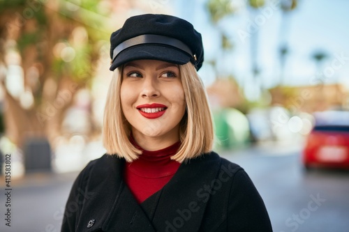 Young blonde woman smiling happy standing at the city.