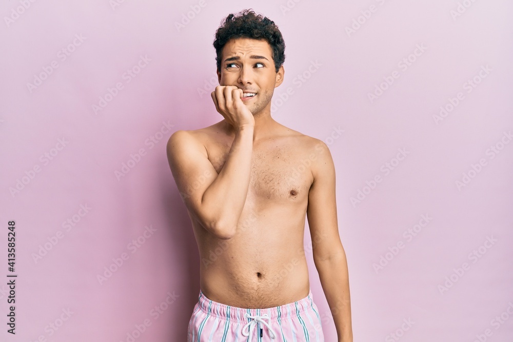 Fototapeta premium Young handsome man wearing swimwear shirtless looking stressed and nervous with hands on mouth biting nails. anxiety problem.
