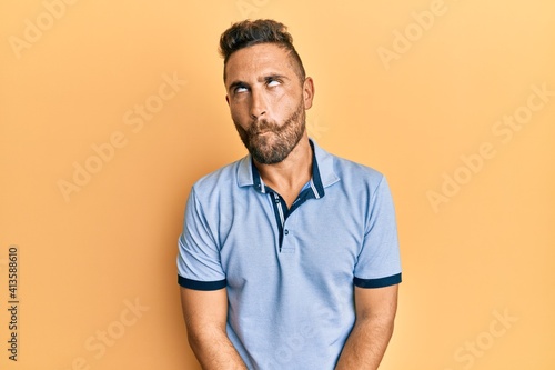 Handsome man with beard wearing casual clothes making fish face with lips, crazy and comical gesture. funny expression.